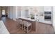 Well-appointed kitchen island with counter seating, modern fixtures, and a view into the entryway at 239 Harvester Rd, Angier, NC 27501