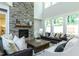 Cozy living room featuring stone fireplace, large windows, and stylish furniture at 274 Golden Leaf Farms Rd, Angier, NC 27501