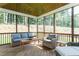 Relaxing screened porch with comfortable seating and views of the wooded backyard at 274 Golden Leaf Farms Rd, Angier, NC 27501