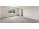 Spacious bedroom with neutral carpeting, large window, and a white door at 236 Moore Creek Dr, Fuquay Varina, NC 27526