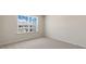 Bright bedroom with a large window, neutral carpet, and wall paint at 236 Moore Creek Dr, Fuquay Varina, NC 27526