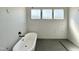 Modern bathroom featuring a freestanding tub, large-format tiles, and three windows offering natural light at 280 Forest Bridge Rd, Franklinton, NC 27525
