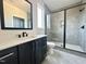 A sophisticated bathroom with a dark vanity, white countertop, and a sleek glass-enclosed shower with gray tiling at 280 Forest Bridge Rd, Franklinton, NC 27525