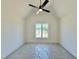 Spacious bedroom with a vaulted ceiling, modern ceiling fan, and a view of new construction through the window at 280 Forest Bridge Rd, Franklinton, NC 27525