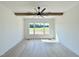 Bedroom with a large window offering ample natural light, complemented by wood ceiling beam and modern ceiling fan at 280 Forest Bridge Rd, Franklinton, NC 27525
