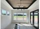 Sunlit dining room featuring large windows with backyard view, wood paneled ceiling, and modern lighting fixture at 280 Forest Bridge Rd, Franklinton, NC 27525