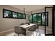 Elegant dining room featuring a stylish light fixture, a wooden table, and large windows with green outdoor views at 280 Forest Bridge Rd, Franklinton, NC 27525
