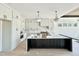 Well-lit kitchen with a large island, stylish pendant lighting, and sleek white cabinets, and stainless steel appliances at 280 Forest Bridge Rd, Franklinton, NC 27525