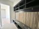 Stylish mudroom features a wood-slat wall with hooks and a black bench and shelving unit for storage at 280 Forest Bridge Rd, Franklinton, NC 27525
