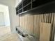 Mudroom with custom cubbies and bench with black shelves and a slat accent wall at 280 Forest Bridge Rd, Franklinton, NC 27525