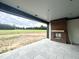 View of outdoor covered patio featuring stone flooring, brick fireplace and expansive lawn at 280 Forest Bridge Rd, Franklinton, NC 27525