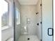 Contemporary shower with black fixtures, neutral herringbone tile, a corner window and hexagon tile flooring at 280 Forest Bridge Rd, Franklinton, NC 27525