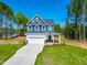New two-story home with blue siding, white trim, gabled roof, front-entry garage, and landscaped front yard at 121 Plainfield Ln # 134, Lillington, NC 27546