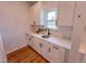 Kitchen area featuring white cabinets, a stainless steel sink and views to the outdoors from the window at 121 Plainfield Ln # 134, Lillington, NC 27546