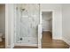 Bright bathroom featuring a standalone shower with glass door and marble tile, and open closet at 233 Surles Rd, Benson, NC 27504