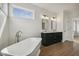Bright bathroom with a soaking tub, bright lighting, and double sink vanity with granite countertop at 233 Surles Rd, Benson, NC 27504