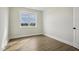 Bedroom featuring a view through the window, neutral walls, modern flooring, and modern trim at 233 Surles Rd, Benson, NC 27504