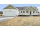 Charming single-story home with a two-car garage, green trim, and freshly laid mulch at 233 Surles Rd, Benson, NC 27504
