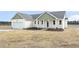 Charming single-story home with a two-car garage, green trim, and freshly laid mulch at 233 Surles Rd, Benson, NC 27504