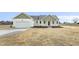 Charming single-story home with a two-car garage, green trim, and freshly laid mulch at 233 Surles Rd, Benson, NC 27504
