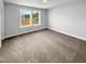 Bright bedroom with plush carpeting, a large double window overlooking the neighborhood and neutral paint at 33 Macy Cir, Wendell, NC 27591
