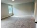 Spacious bedroom featuring soft carpeting and natural light from a window at 33 Macy Cir, Wendell, NC 27591