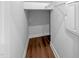 Walk-in closet featuring built-in shelving, hardwood flooring, and a fresh coat of neutral paint at 33 Macy Cir, Wendell, NC 27591