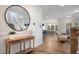 Inviting entryway with wood floors and a large round mirror reflecting the staircase and open concept living area at 33 Macy Cir, Wendell, NC 27591