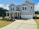 Charming two-story home with a covered porch, two-car garage, and manicured front yard at 33 Macy Cir, Wendell, NC 27591