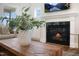 Close-up of a cozy fireplace with a black marble surround, a decorative mantel, and a rustic wood coffee table at 33 Macy Cir, Wendell, NC 27591