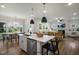 Bright open-concept kitchen with stainless steel appliances, island with seating, and adjacent living room with fireplace at 33 Macy Cir, Wendell, NC 27591