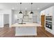 Modern kitchen featuring a central island with seating, stainless steel appliances and wood flooring at 33 Macy Cir, Wendell, NC 27591