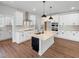 Bright, open kitchen with stainless steel appliances, a large island, white cabinetry and modern finishes at 33 Macy Cir, Wendell, NC 27591