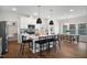 Stylish kitchen with white cabinets, a large island with seating, stainless steel appliances, and an adjacent dining area at 33 Macy Cir, Wendell, NC 27591