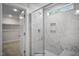 Modern bathroom shower with marble tiling, glass door and window at 33 Macy Cir, Wendell, NC 27591