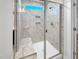 Bathroom featuring an updated shower with a glass door, bench, marble tiles, and natural light from window at 33 Macy Cir, Wendell, NC 27591