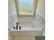 Close-up of the garden tub with marble tile surround and black fixtures at 40 Sunrise Ct, Spring Hope, NC 27882
