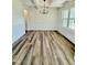 Dining room with wainscoting, a modern chandelier, wood-look floors, and bright natural light at 40 Sunrise Ct, Spring Hope, NC 27882