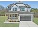 Beautiful two-story home featuring a gray exterior, stone accents, a welcoming porch, and an attached two-car garage at 40 Sunrise Ct, Spring Hope, NC 27882