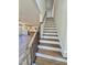 Staircase featuring wood treads, black metal balusters, and views of the kitchen at 40 Sunrise Ct, Spring Hope, NC 27882