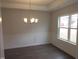 Dining room with wainscoting, modern chandelier, and large window at 73 High Hampton Way, Fuquay Varina, NC 27526