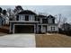 Two-story home with stone accents, an attached two-car garage, and a well-manicured lawn at 73 High Hampton Way, Fuquay Varina, NC 27526