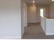 Hallway with carpet and neutral paint color and open railing at 73 High Hampton Way, Fuquay Varina, NC 27526