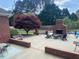 Backyard patio area with fireplace, outdoor seating, and landscaped garden near pool at 166 Weldon Dr, Clayton, NC 27520