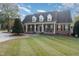 Charming brick home with a large front yard, symmetrical landscaping, and black shutters at 166 Weldon Dr, Clayton, NC 27520