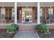 Charming front porch with brick facade, rocking chairs, and beautifully landscaped entrance at 166 Weldon Dr, Clayton, NC 27520