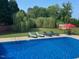 An inviting backyard pool area with comfortable lounge chairs and lush greenery at 166 Weldon Dr, Clayton, NC 27520