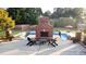 The backyard features a pool and outdoor brick fireplace, great for relaxing and entertaining at 166 Weldon Dr, Clayton, NC 27520