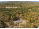 Aerial view of the home nestled in the forest surrounded by fall foliage at 1414 Whippoorwill Ln, Chapel Hill, NC 27517
