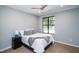 This bedroom features a ceiling fan, neutral colored walls, wood flooring and a window with a view of mature trees at 1414 Whippoorwill Ln, Chapel Hill, NC 27517